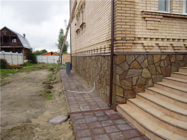 Оформление фундамента искусственным камнем.